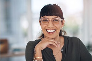 a smiling woman with her hand under her chin