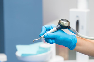 a dental hygienist holding an Airflow dental tool